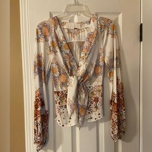 Free People women’s blouse. Low v-neck with buttons and a tie.
